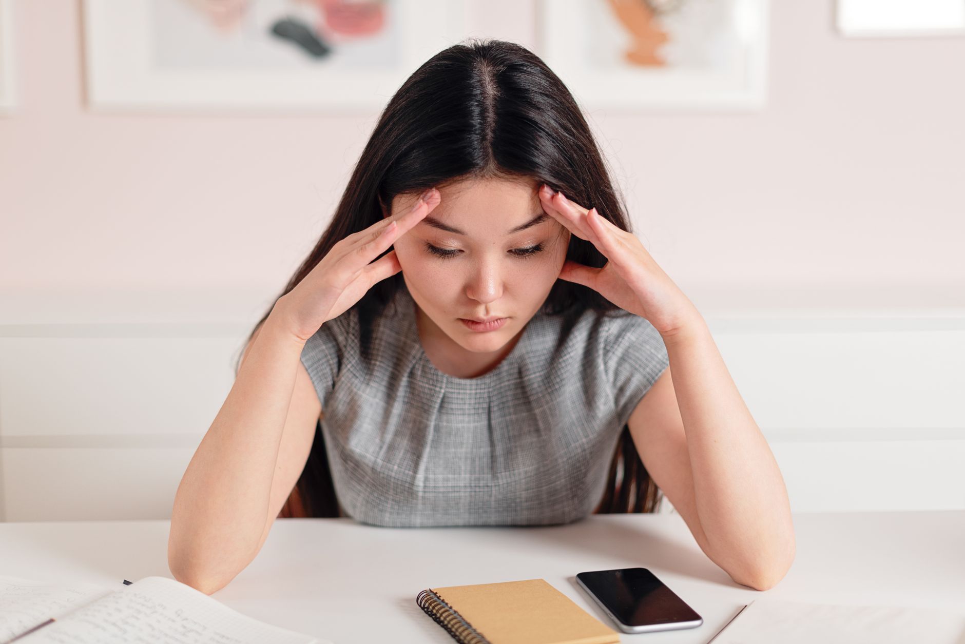Overwhelmed person with head in hands