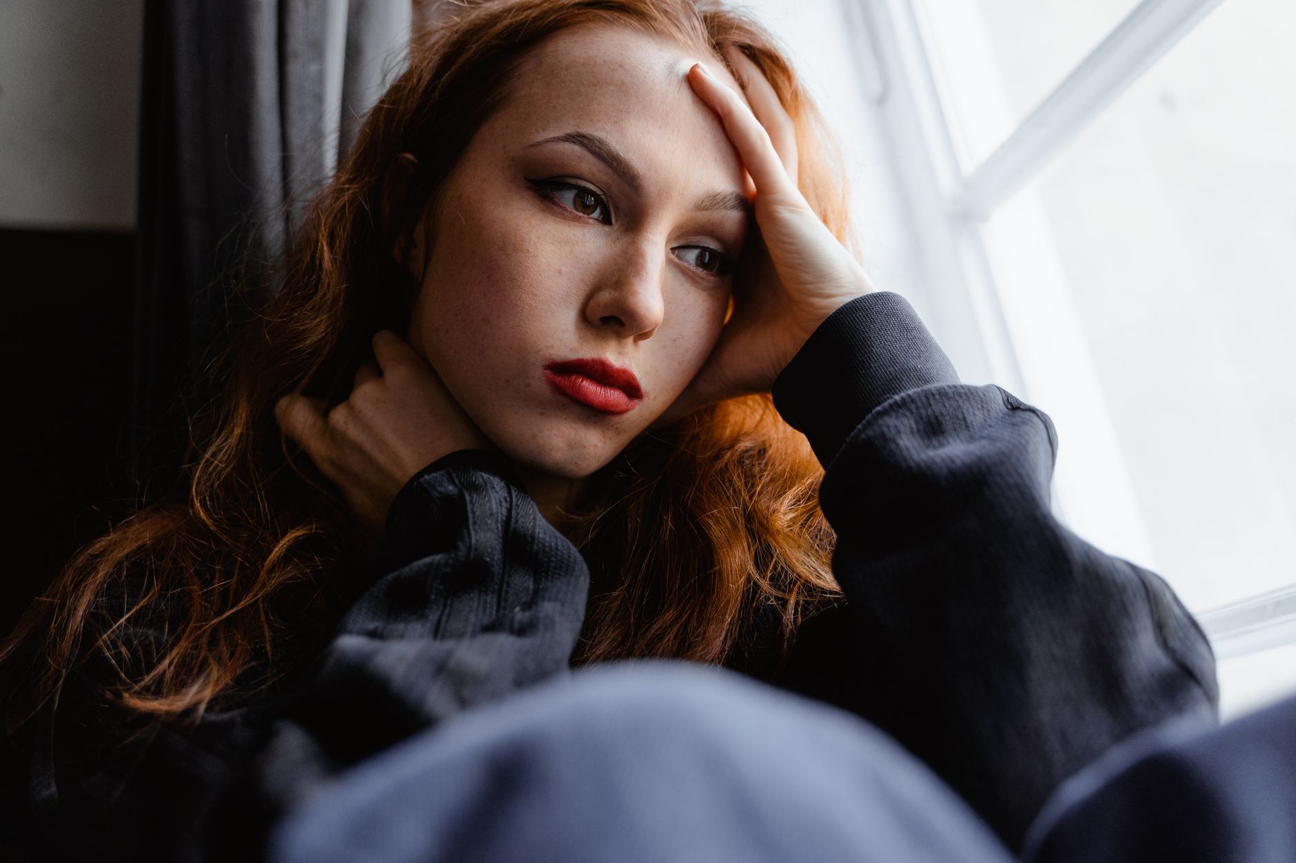 Woman thoughtfully reflecting by a window