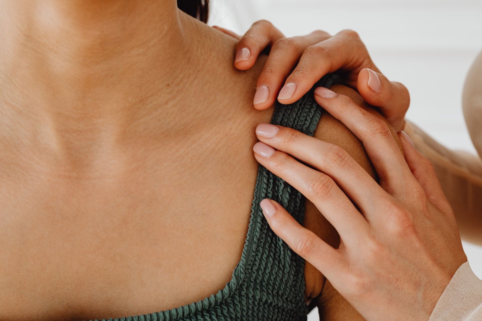 Gentle, supportive hand on shoulder