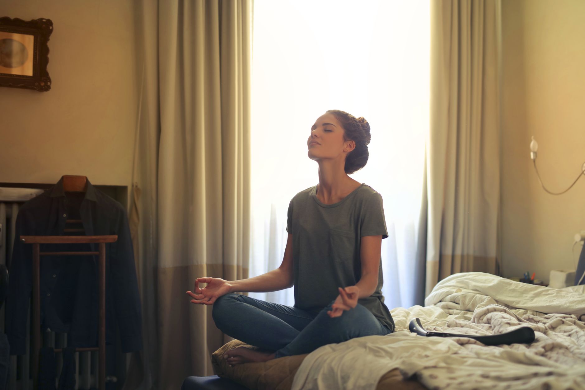 Woman meditating peacefully in soft morning light at home