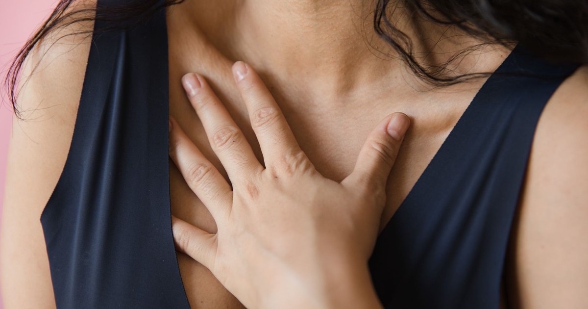 Person placing a hand on their chest while calming down