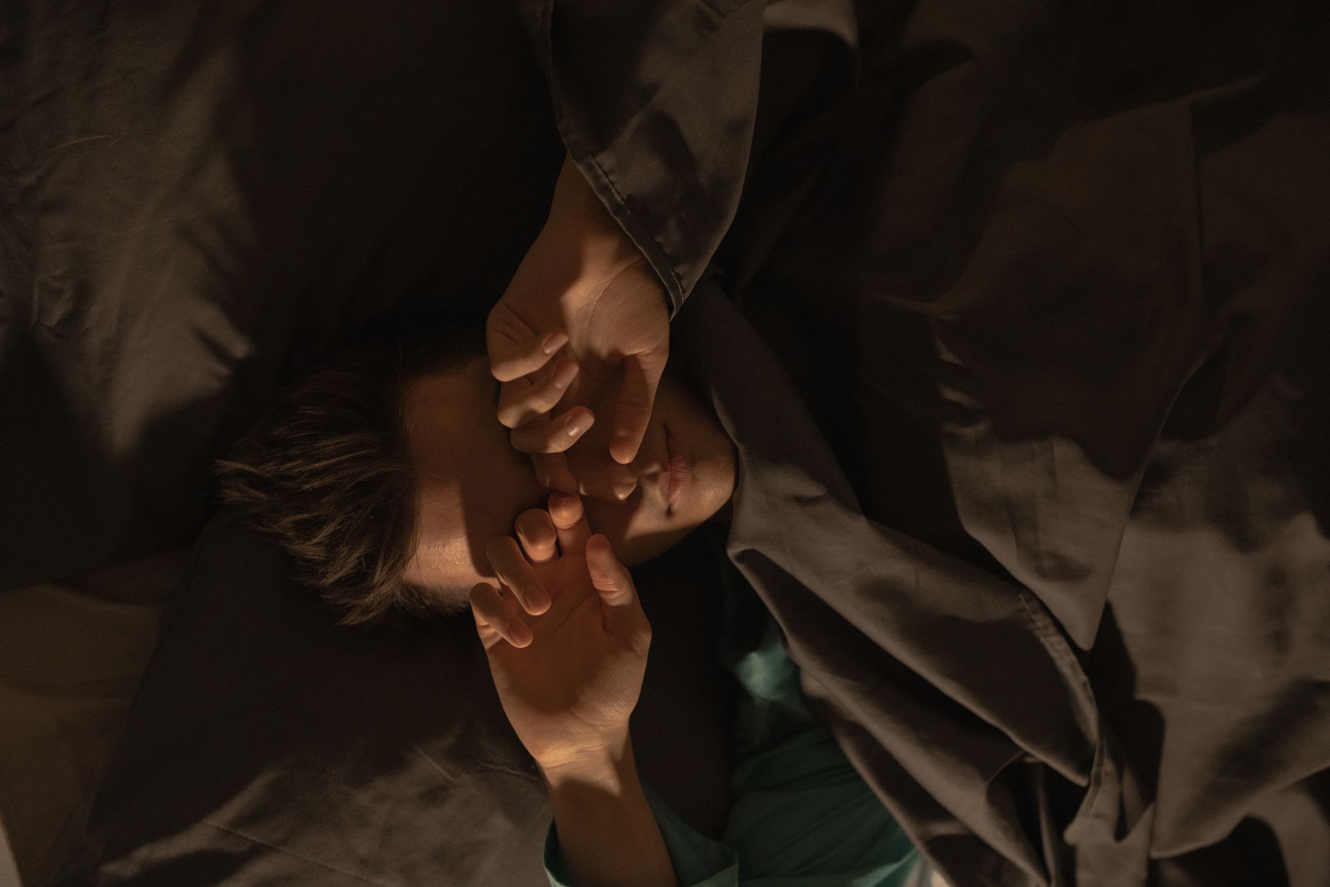Person struggling with sleep, tired in bed