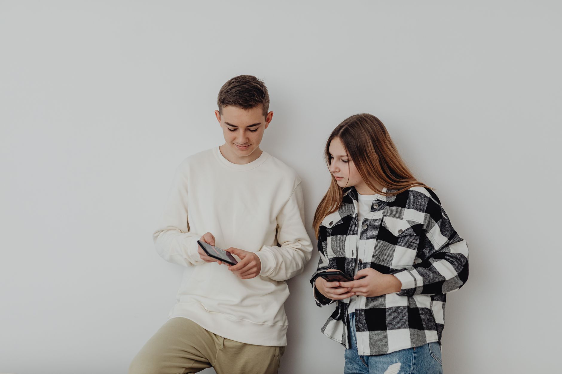 Teen boy distracted by phone while studying