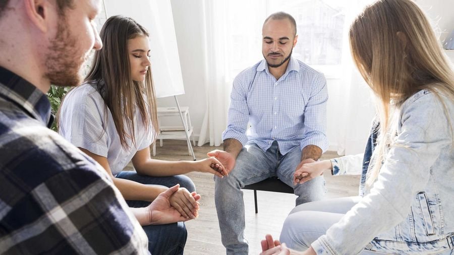 Group of adults sitting in a circle during a family therapy session