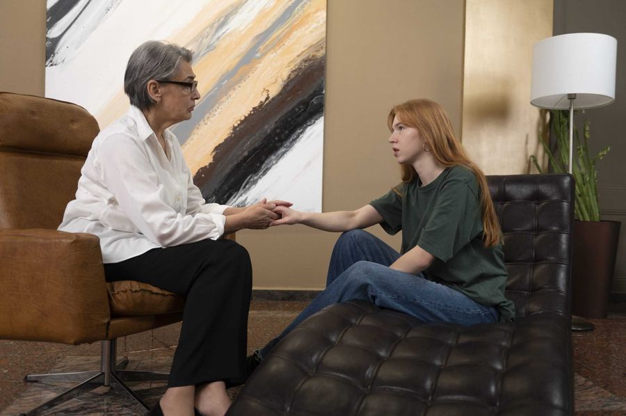 Therapist holding a client's hand during a trauma-focused therapy session