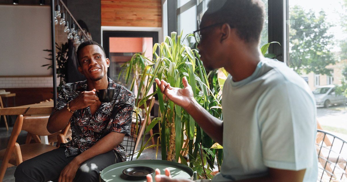 Two friends having a calm, supportive conversation over coffee