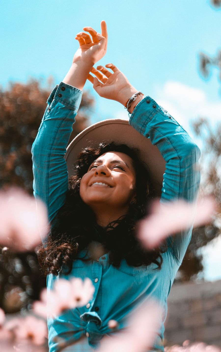 Smiling woman with arms raised outdoors, representing hope and renewal through psychotherapy