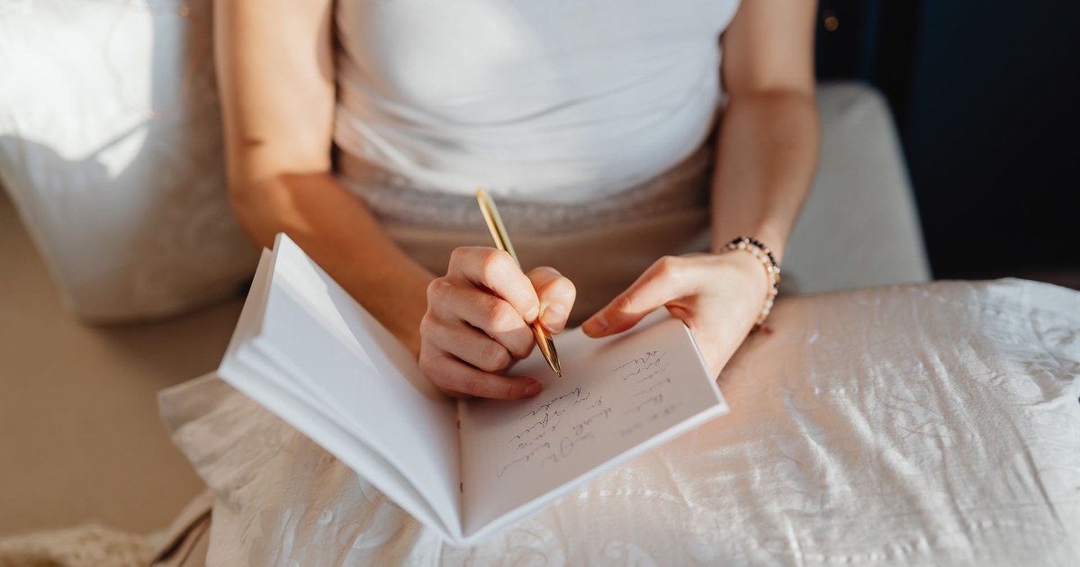 A woman writing in a notebook, reflecting on what she actually wants