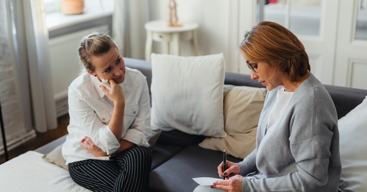 A woman talking openly with her therapist in a warm, calm setting